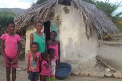 DALL·E-2023-02-24-18.29.01-family-standing-in-front-of-hut-3